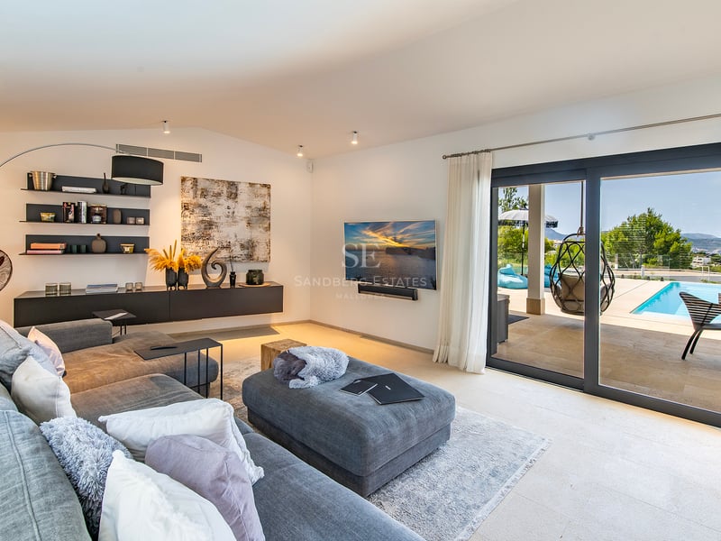 Vue extérieure d'une villa moderne avec piscine à débordement, jardin luxuriant et vastes terrasses. Design minimaliste et finitions haut de gamme.