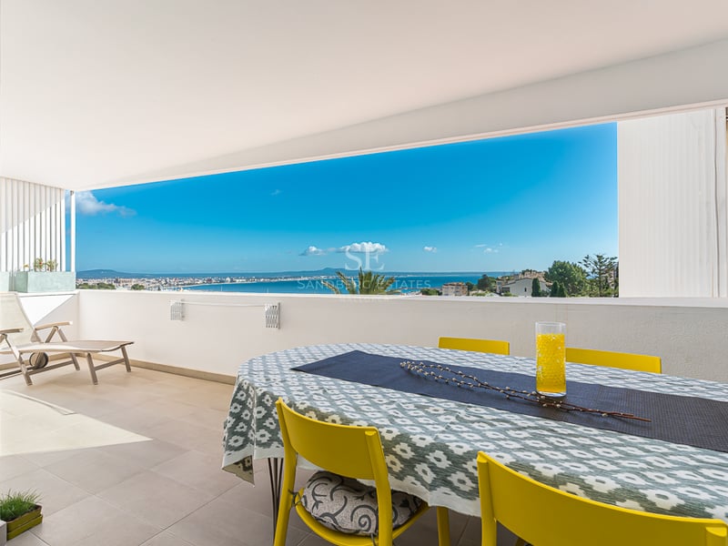 Grande terrasse avec piscine à débordement et vue sur la mer. Mobilier moderne et minimaliste. Éclairage d'ambiance.