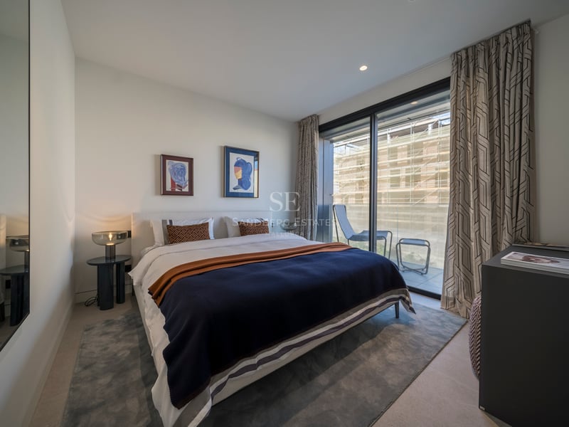Chambre à coucher contemporaine avec un grand lit, des baies vitrées et une terrasse privée attenante.
