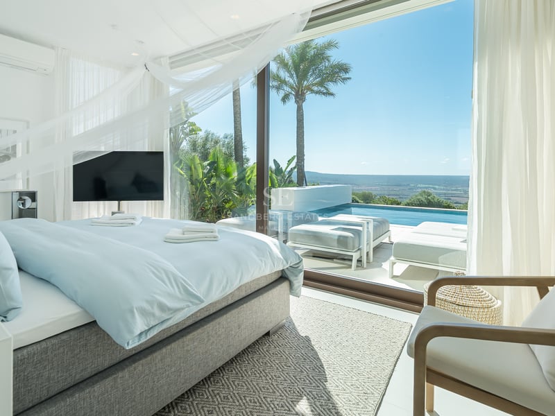 Vaste salon avec baies vitrées panoramiques, cheminée moderne et design minimaliste. Vues spectaculaires sur la mer.