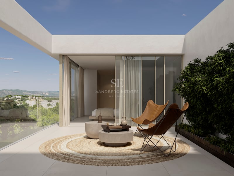 Terrasse contemporaine avec fauteuils en cuir, tapis en jute et garde-corps en verre surplombant la vallée.