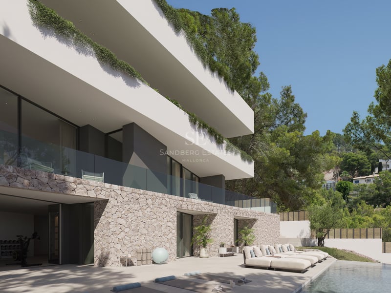 Terrasse de piscine avec bains de soleil et tapis de yoga devant une villa moderne en pierre et blanc.