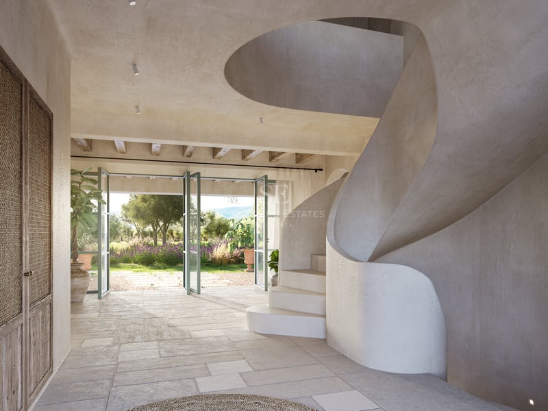 Entrée spacieuse avec escalier en colimaçon blanc, sol en pierre et portes vitrées ouvrant sur un jardin méditerranéen.