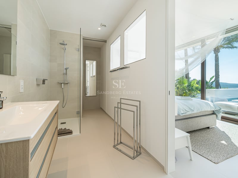 Balcon moderne avec rambarde en verre, vue imprenable, mobilier d'extérieur élégant et plancher en bois. Design minimaliste et lumineux.