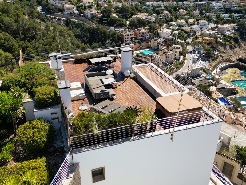 Vue aérienne d'une terrasse moderne en bois sur un toit, équipée d'un jacuzzi, d'un salon de jardin et d'un coin repas.