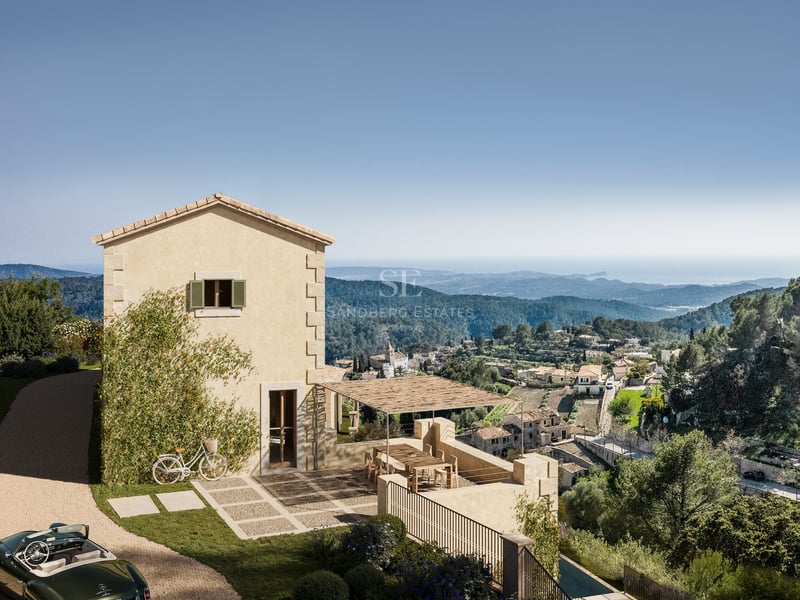 Villa en pierre sur une colline surplombant une vallée et la mer avec une voiture décapotable classique sur le chemin.