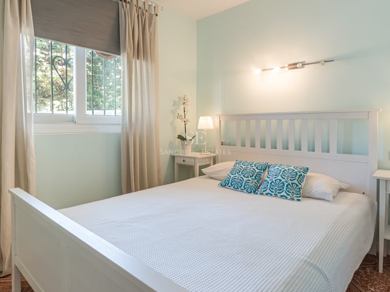 Chambre vert menthe avec lit en bois blanc, tables de chevet assorties et sol en carrelage traditionnel.