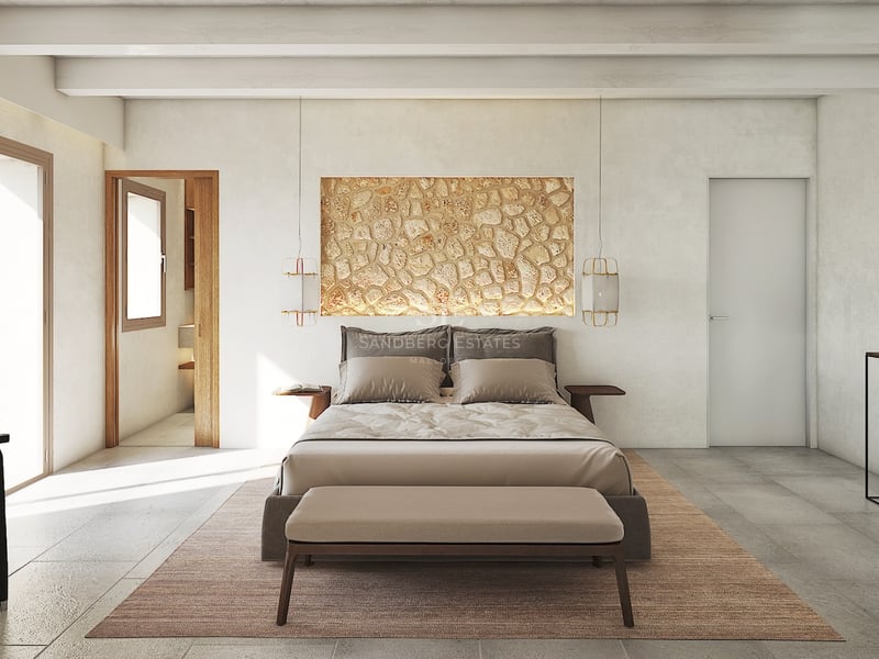 Dormitorio principal moderno con pared de piedra natural, vigas vistas y puertas de cristal de suelo a techo.