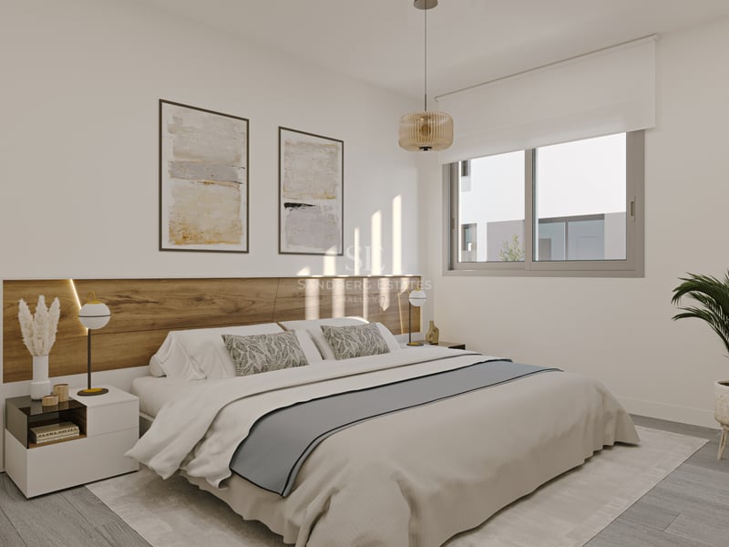 Dormitorio principal moderno con cabecero de madera integrado, ventana grande, ropa de cama neutra y planta de interior.