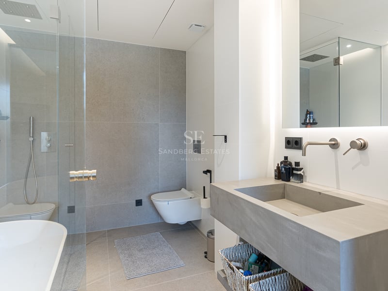 Salle de bains contemporaine avec carrelage gris, douche à l'italienne, vasque intégrée et miroir rétroéclairé.