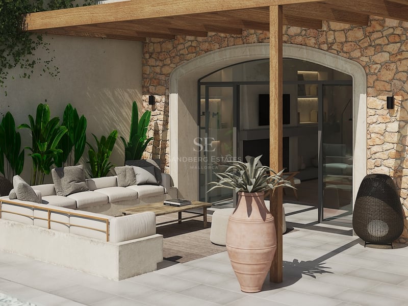 Salón exterior de lujo con sofá integrado, pérgola de madera y pared de piedra natural bajo la luz del sol.