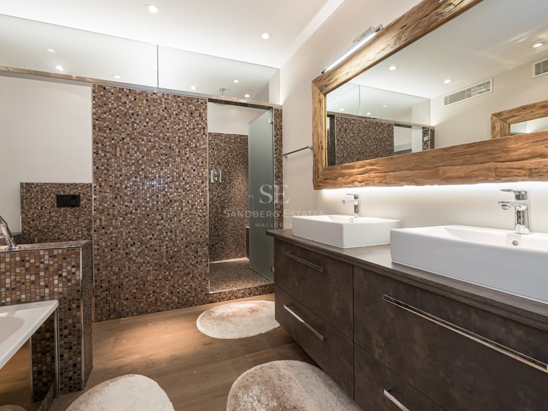 Salle de bains moderne avec double vasque, grand miroir encadré de bois brut et douche à l'italienne en mosaïque.