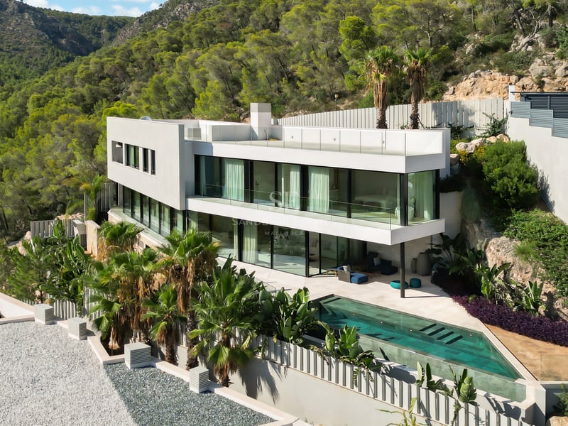 Vue extérieure d'une villa luxueuse avec piscine à débordement, jardin luxuriant et architecture moderne. Idéal pour investissement.