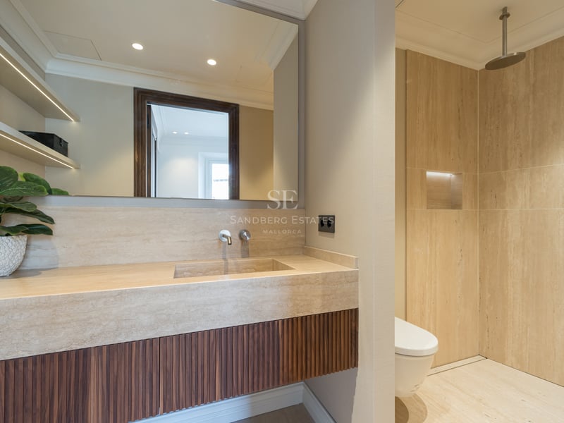 Modern bathroom featuring a travertine stone vanity with a fluted wood cabinet and a walk-in rain shower.