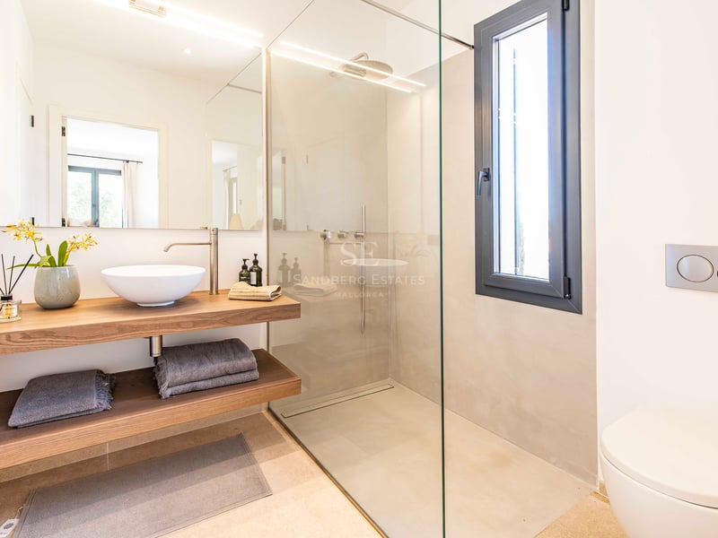 Contemporary bathroom featuring a glass walk-in shower, floating oak vanity with vessel sink, and backlit mirror.