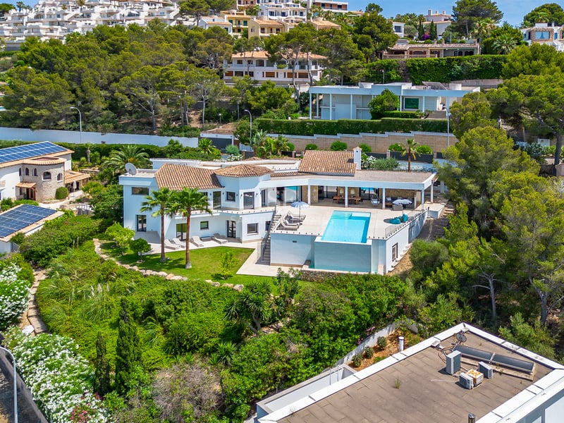Vue extérieure d'une maison moderne avec piscine. Architecture minimaliste, grandes baies vitrées, jardins luxuriants et aménagement paysager élégant.