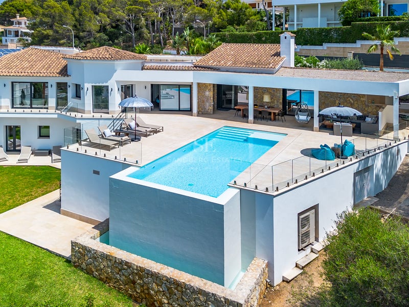 Salon spacieux avec baies vitrées, mobilier moderne et accès à un balcon avec vue imprenable. Élégance et luminosité.