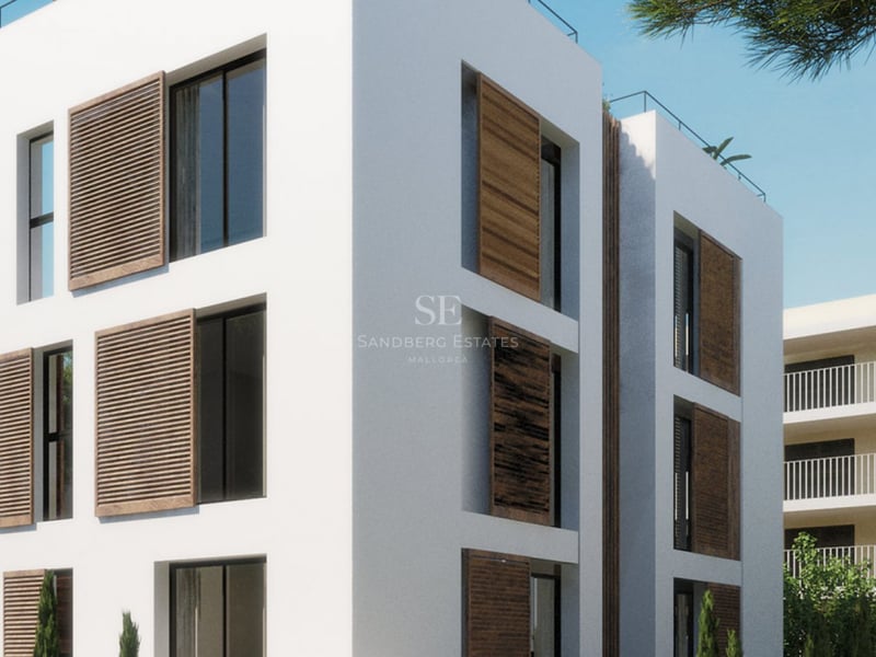 Immeuble blanc moderne à plusieurs étages avec de grandes fenêtres et des volets coulissants en bois sous un ciel bleu clair.