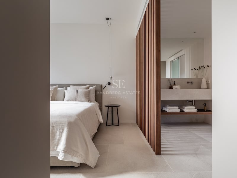 Chambre principale moderne avec claustra en bois et salle de bain attenante intégrée avec vasque en pierre.