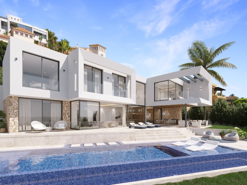 Villa moderne blanche avec piscine à débordement, chaises longues, garde-corps en verre et murs en pierre naturelle.