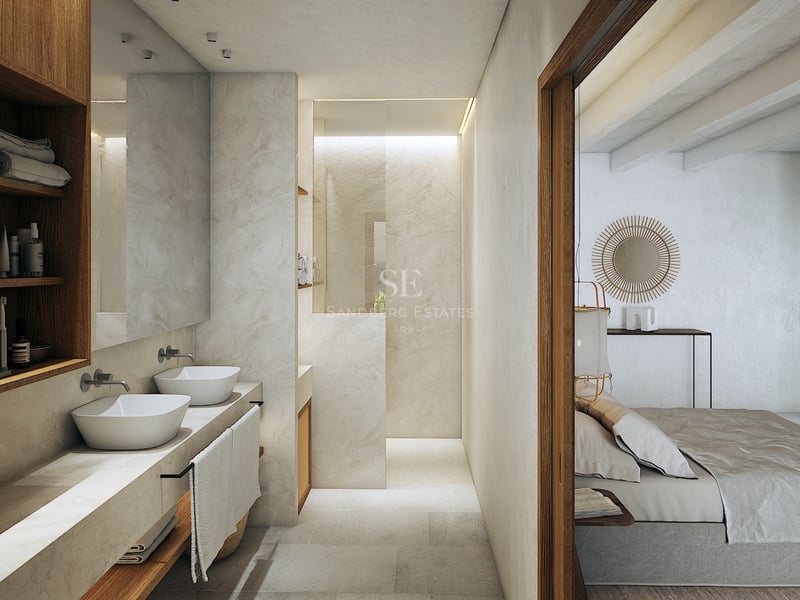 Baño minimalista con lavabos dobles sobre encimera de piedra, estantes de roble y ducha de obra.