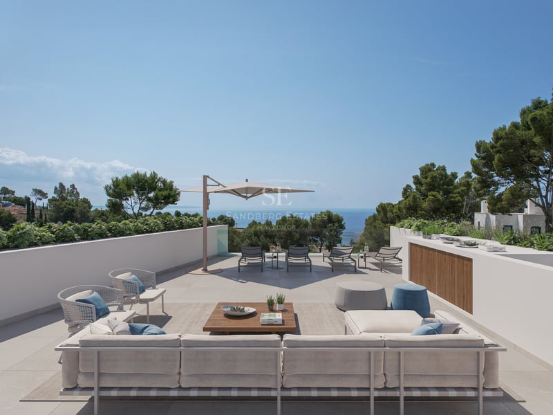 Grande terrasse moderne avec canapés, chaises longues et vue imprenable sur la mer Méditerranée.