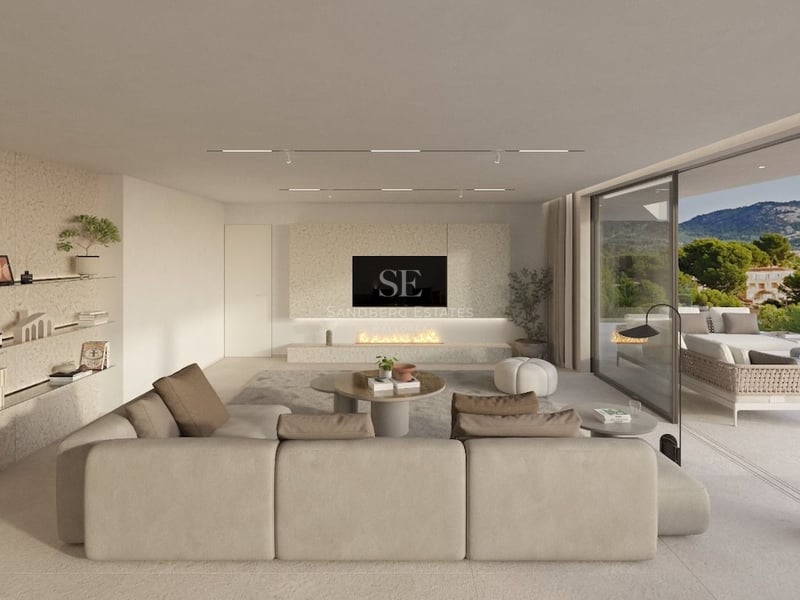 Salon spacieux aux tons neutres avec grand canapé, cheminée intégrée et baies vitrées ouvrant sur la terrasse.