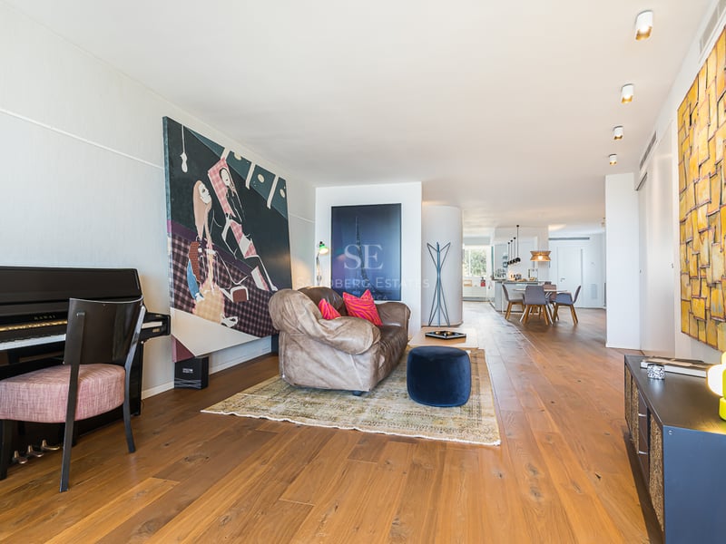 Vue d'une villa moderne avec piscine à débordement, chaises longues et végétation luxuriante. Design élégant et contemporain.