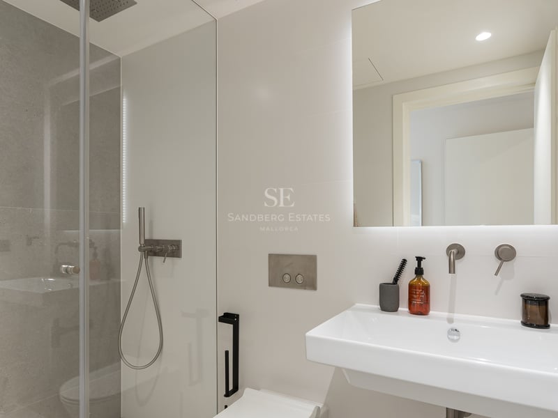 Salle de bains contemporaine avec douche à l'italienne, vasque blanche et grand miroir rétroéclairé.