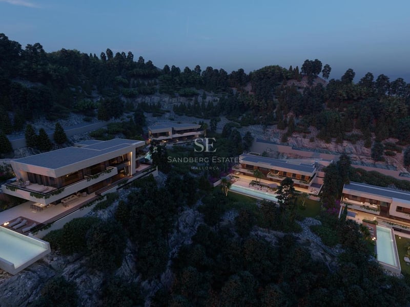 Vue aérienne au crépuscule de villas de luxe contemporaines avec piscines à débordement sur une colline arborée.