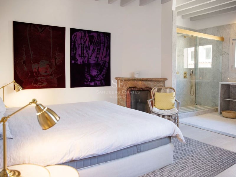 Dormitorio principal contemporáneo con chimenea rústica, ducha de mármol integrada y elegantes lámparas de latón.