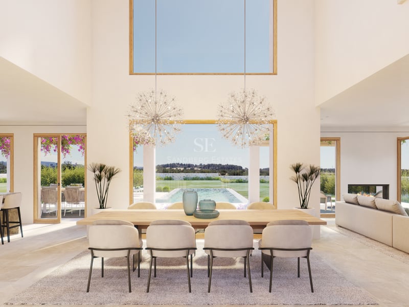 Salle à manger moderne avec table en chêne, lustres en cristal et vue sur la piscine à travers de grandes baies vitrées.