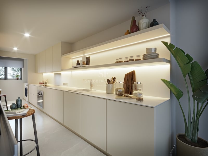 Cuisine moderne beige avec de longs plans de travail, étagères ouvertes éclairées par LED et une grande plante verte.
