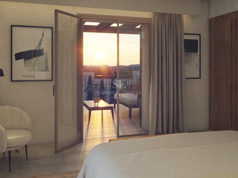 Dormitorio contemporáneo con puertas de cristal a una terraza con vistas al valle durante el atardecer.