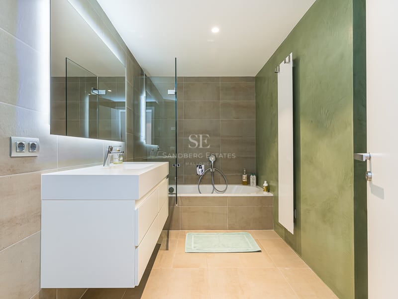 Vue extérieure d'une villa moderne avec piscine, jardin luxuriant et architecture minimaliste. Éclairage chaleureux et détails de design.