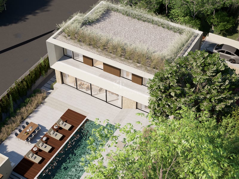 Vue aérienne d'une villa blanche contemporaine avec toit végétalisé, piscine turquoise et terrasse aménagée.