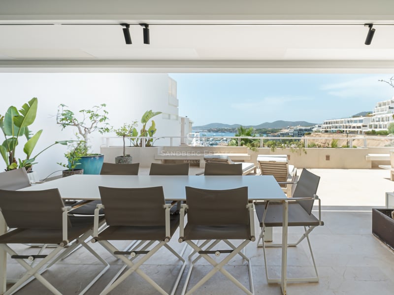 Terrasse moderne avec coin repas, barbecue et vue panoramique sur la côte et la mer.