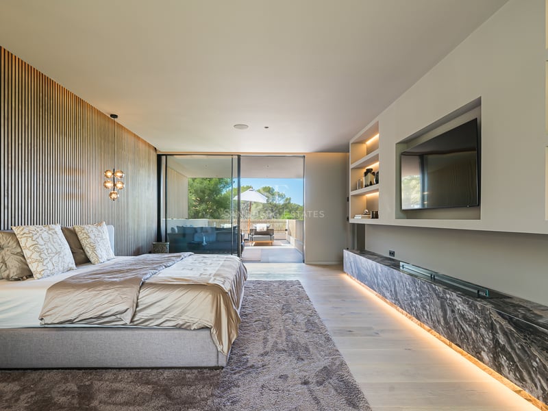 Chambre moderne avec mur en tasseaux de bois, grand lit, accents de marbre et accès à la terrasse.