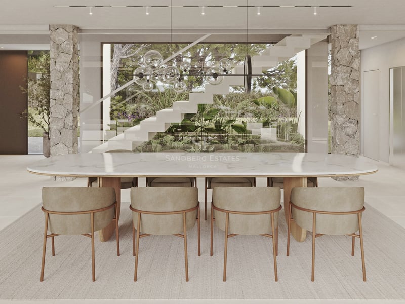Salle à manger élégante avec table en marbre blanc, piliers en pierre et vue sur un escalier design et jardin luxuriant.