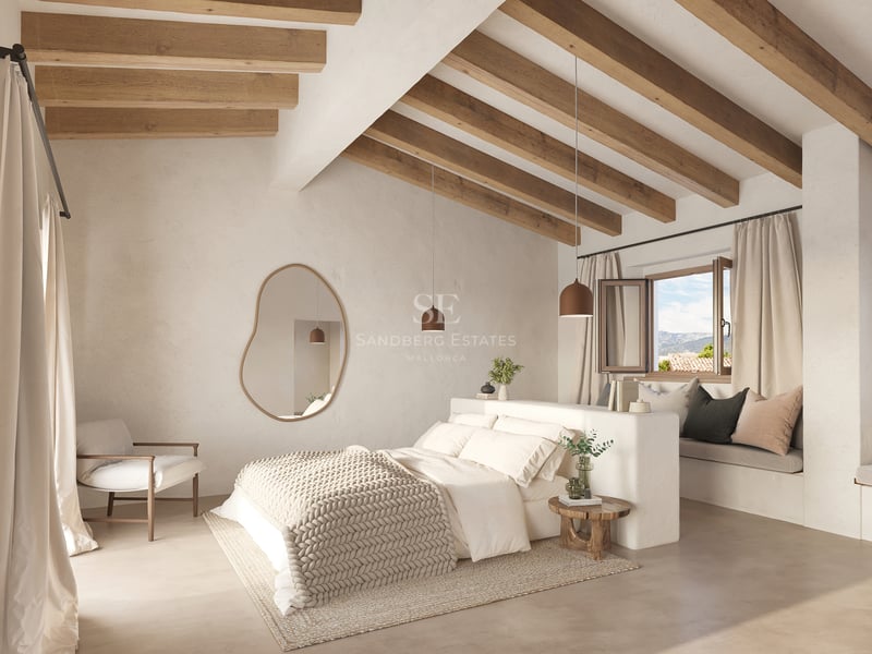 Chambre lumineuse avec hauts plafonds, poutres en bois, grand lit et miroir mural de forme organique.