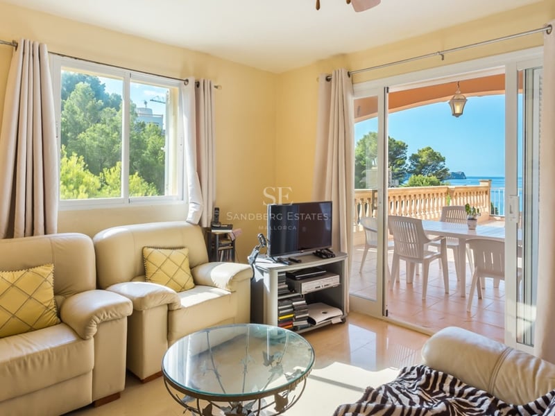Intérieur lumineux avec grandes fenêtres, parquet clair, mobilier moderne. Vues panoramiques sur la mer.