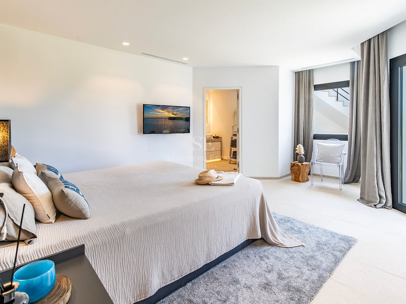 Grand balcon avec vue sur la mer, mobilier moderne, balustrade en verre, plancher en bois, idéal pour profiter du plein air.