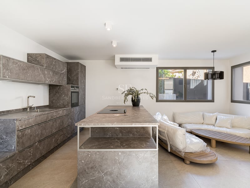 Cuisine contemporaine avec meubles effet marbre gris, îlot central et appareils électroménagers intégrés.