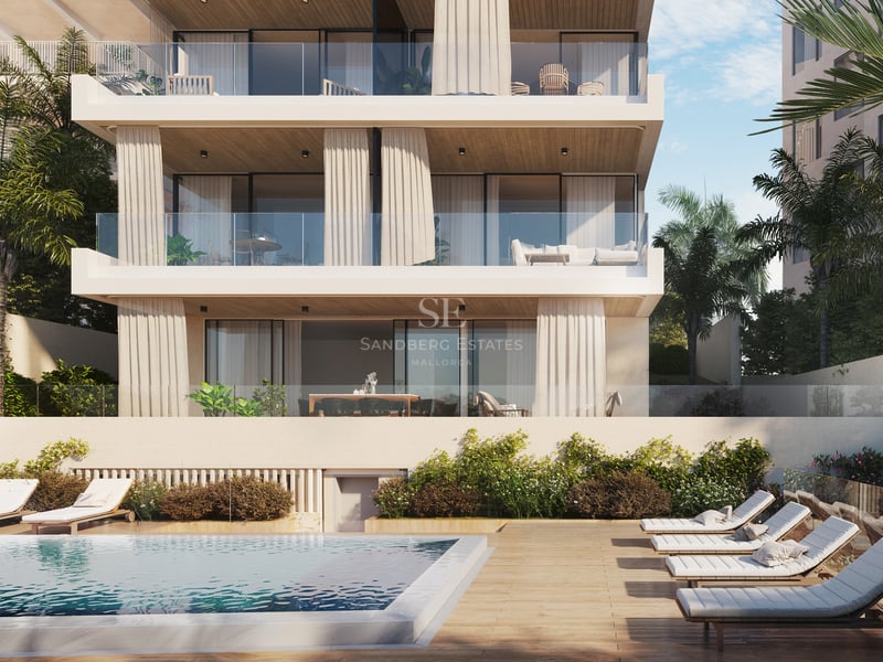 Façade d'un immeuble de luxe avec piscine, terrasse en bois avec bains de soleil et terrasses vitrées.