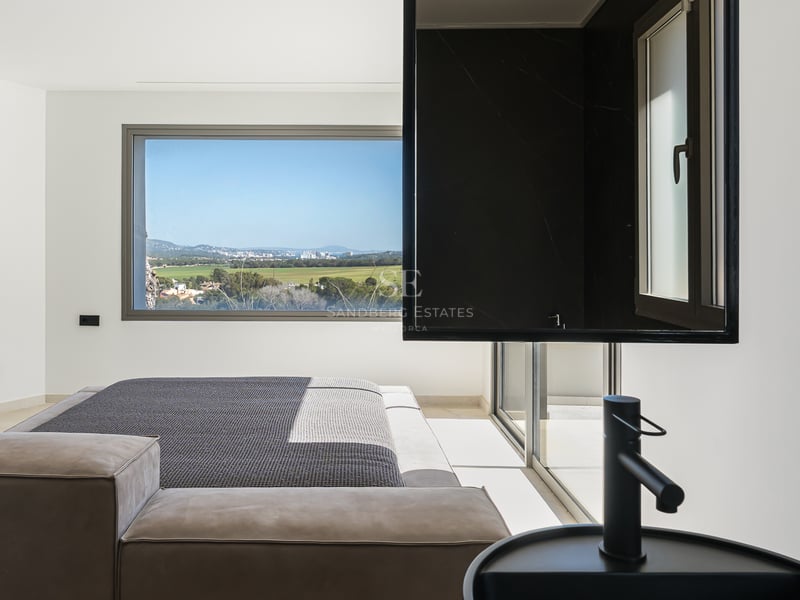 Chambre principale contemporaine avec vasque noire intégrée et grande fenêtre donnant sur une vallée verdoyante.