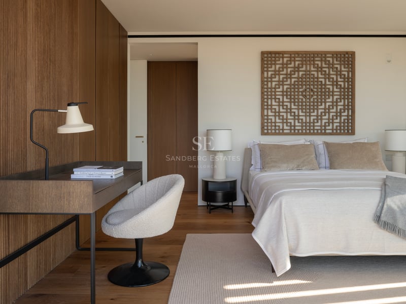 Chambre moderne avec mur en tasseaux de bois, bureau intégré, chaise en bouclé et textiles aux tons neutres.