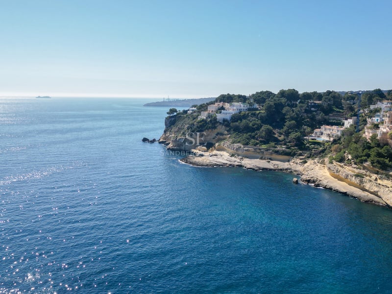 Vue par drone de falaises avec des villas de luxe surplombant la mer Méditerranée étincelante.