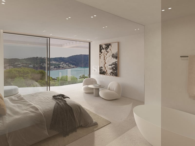 Chambre moderne avec baies vitrées, vue sur la baie, baignoire intégrée et mobilier design aux tons neutres.