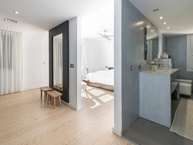 Suite parentale moderne avec parquet en chêne, vasque en béton ciré et placards intégrés blancs.
