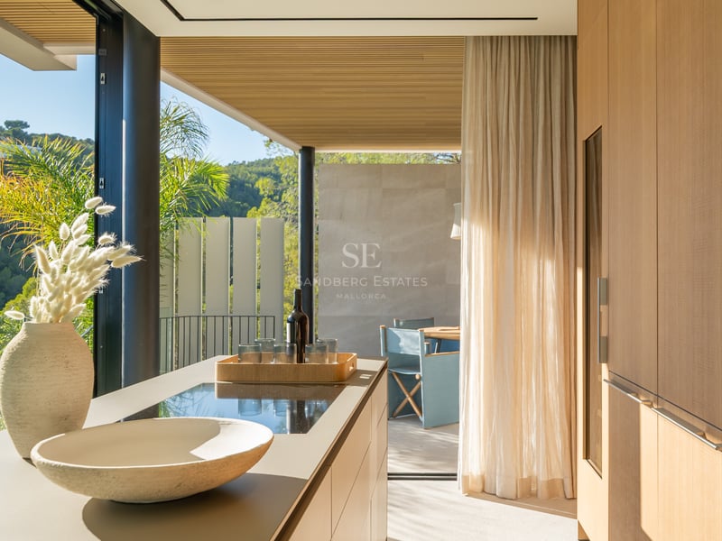 Vaste terrasse avec piscine à débordement, vue sur mer et mobilier moderne. Architecture minimaliste avec finitions haut de gamme.